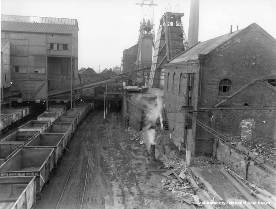A black and white photograph showing the railway sidings at Chatterley Whitfield Colliery. There are lines of wagons awaiting coal to be tipped into them.